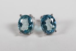 A pair of light blue topaz stud earrings on silver posts