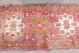 A Persian red ground full pile hand woven wood runner with a cream and amber medallion design, A/F