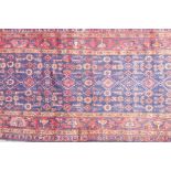 A large blue ground hand woven Persian runner with an all over design within a red border, 44" x