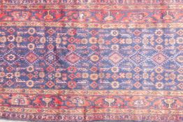 A large blue ground hand woven Persian runner with an all over design within a red border, 44" x