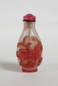 A Peking glass snuff bottle with carved pink carp and lotus flower decoration,