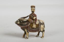 A C19th carved and stained bone snuff bottle in the form of a Chinese man riding a yak, 3" high