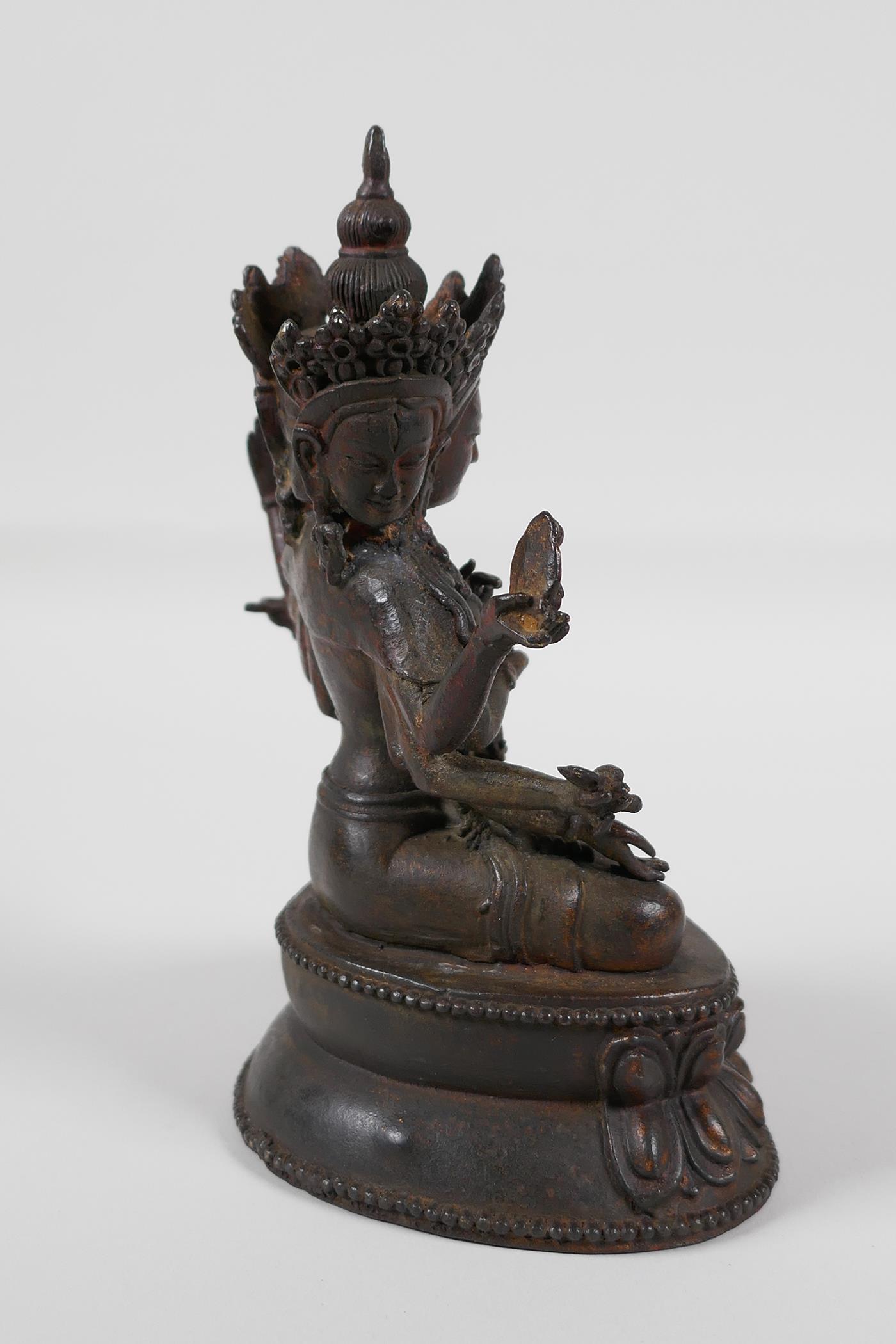 A Sino-Tibetan bronze of a many armed deity, seated on a lotus throne. Carrying auspicious items, - Image 3 of 4