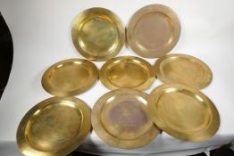 A set of eight C19th brass plates, 12" diameter