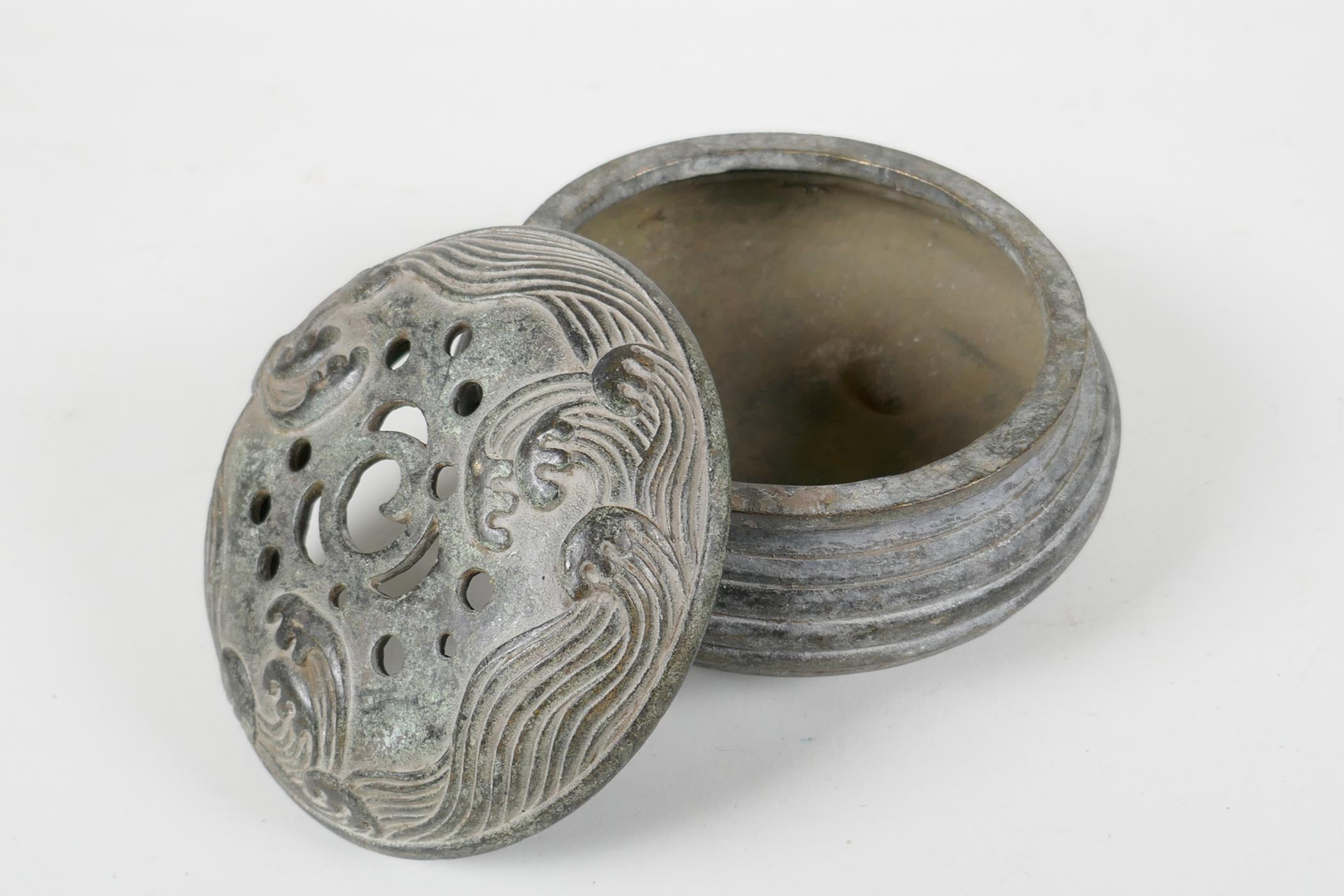 A Chinese archaic style bronze censer & cover with raised wave decoration to cover, raised on tripod - Image 3 of 4