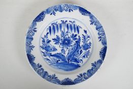 An C18th/C19th Delft blue and white charger with hand painted floral decoration, 14" diameter