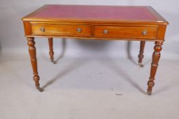 A mahogany writing table with two true and two false drawers, and inset gilt tooled leather top,
