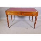 A mahogany writing table with two true and two false drawers, and inset gilt tooled leather top,