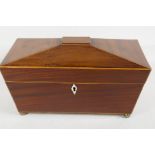 A C19th sarcophagus shaped mahogany tea caddy with satinwood stringing on brass feet with two lead
