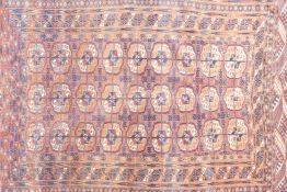 A Turkmen rust ground wool rug with Bokhara pattern, A/F repairs, circa 1930s, 43" x 67"