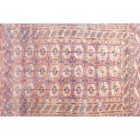 A Turkmen rust ground wool rug with Bokhara pattern, A/F repairs, circa 1930s, 43" x 67"