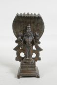 An Indian bronze figure of Shiva standing before seven serpents, 6" high