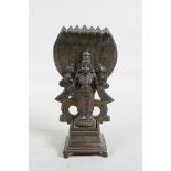 An Indian bronze figure of Shiva standing before seven serpents, 6" high