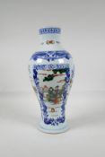 A blue & white porcelain vase with decorative famille vert panels, depicting figures in landscape