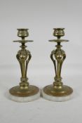 A pair of antique bronze candlesticks with pierced triform phoenix shaped stems with paw feet,