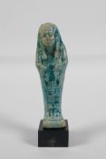 An Egyptian turquoise glazed faience shabti, 4½ h