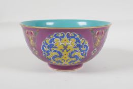 A Chinese polychrome porcelain rice bowl, decorated with stylised dragons, auspicious symbols &