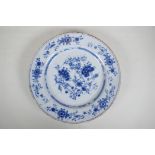 An C18th/C19th Delft blue and white charger with hand painted floral decoration, 14" diameter