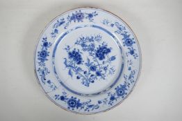 An C18th/C19th Delft blue and white charger with hand painted floral decoration, 14" diameter