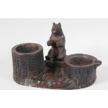 A Black Forest carved wood smokers stand, with tree stump ashtray and cigarette tub, and a seated