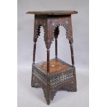 A C19th Moorish two tier stand of tapering form with all over carved decoration and Mother of