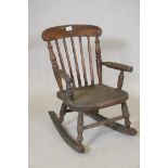 A child's elm Windsor stick back rocking chair, 24" high, 11" wide