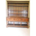 A Georgian Welsh oak pot board dresser, the delft rack with planked back and hand forged hooks,