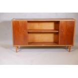A mid century teak dwarf bookcase with two doors flanking open shelves, 54" x 10" x 30"