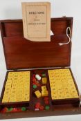 An oak box containing a mahjong set, complete with instructions