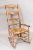 A C19th elm bar back open arm rocking chair, with cane seat