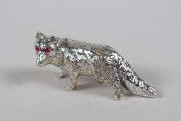 A miniature sterling silver figure of a fox with ruby set eyes, 1½" long