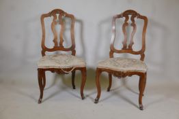 A pair of C18th French walnut pierced splat back side chairs with finely carved decoration, raised