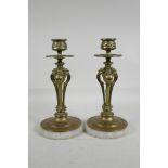 A pair of antique bronze candlesticks with pierced triform phoenix shaped stems with paw feet,