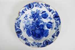 An C18th/C19th Delft blue and white charger with hand painted floral decoration, 14" diameter, A/F