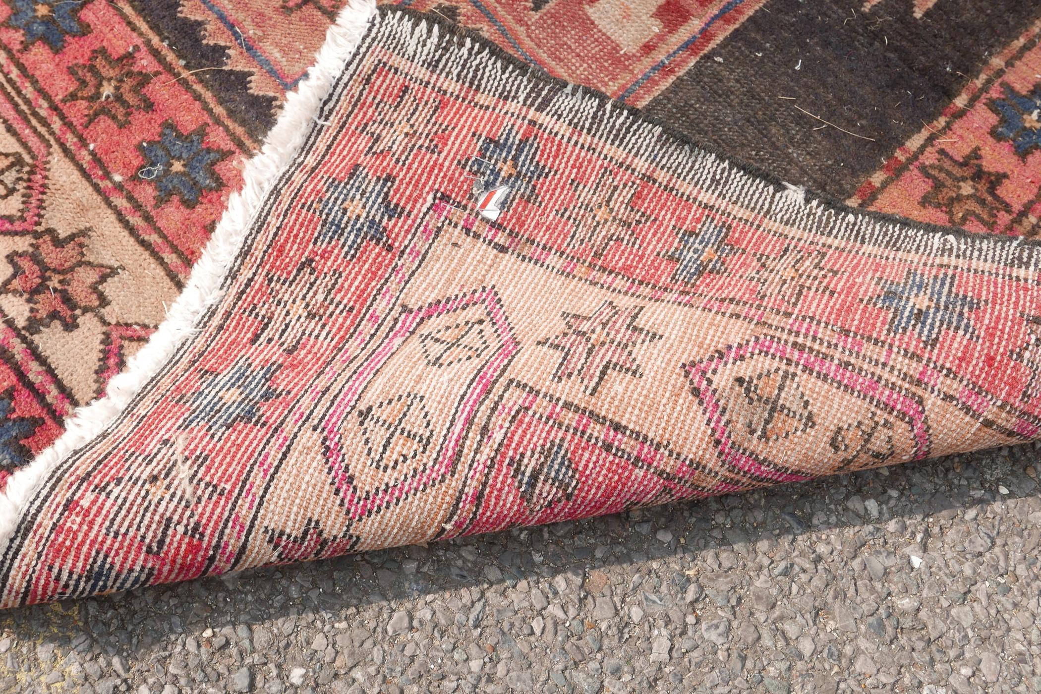 A Persian black ground hand woven wool runner with a repeating rust coloured medallion design within - Image 6 of 6