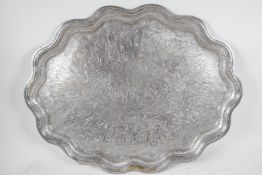 A large petal rimmed silver plated tray, engraved with many Eastern figures, 26½" x 20½"