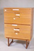 A mid century Uniflex teak six drawer chest with cup handles, raised on shaped supports, 30" x 18" x