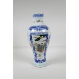 A blue & white porcelain vase with decorative famille vert panels, depicting figures in landscape