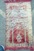 A red ground tassled prayer rug depicting two Mosques, 42" x 23"