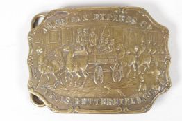 A vintage brass belt buckle, embossed with a horse drawn carriage advertising American Express H. E.