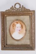 An early C19th miniature portrait of a Georgian child, in elaborate gilt metal frame, portrait 1½" x