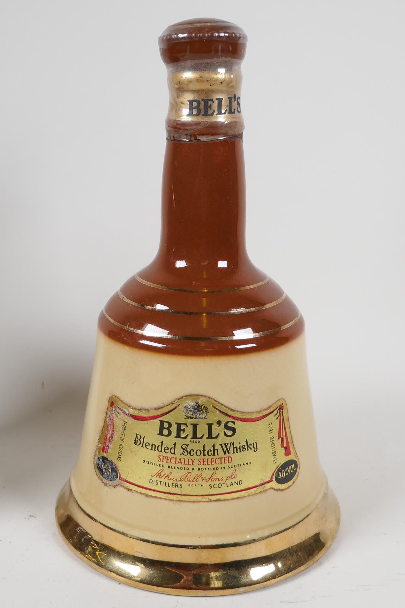 A sealed Wade Bells decanter, containing 75cms of Bell's Scotch Whisky 9½" high