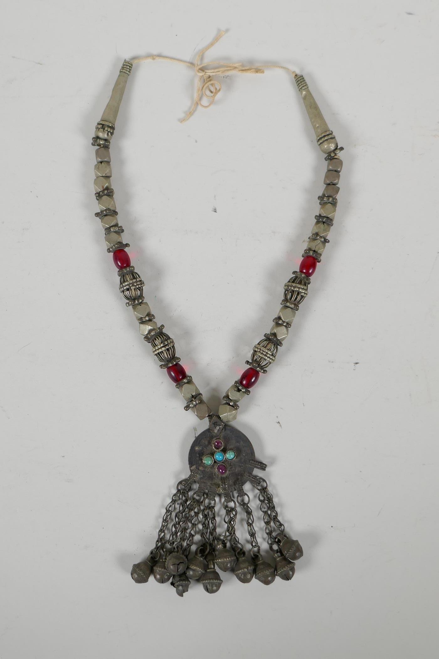 A Turkmen white metal & bead necklace with an Ottoman coin feature pendant, set with stones & bells,