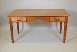 A pine two drawer writing table with two frieze drawers on turned supports, 30" high, 59" wide,
