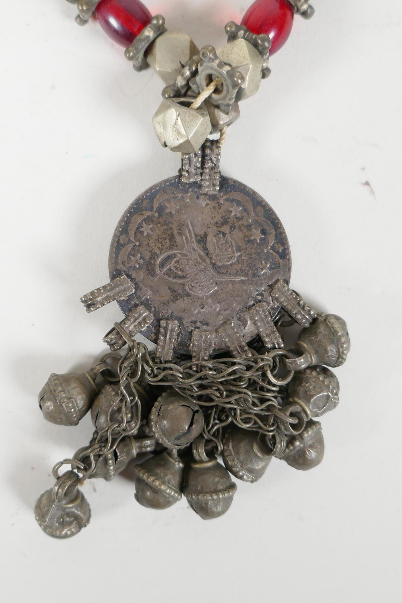 A Turkmen white metal & bead necklace with an Ottoman coin feature pendant, set with stones & bells, - Image 4 of 4