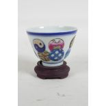 A Chinese polychrome porcelain tea bowl on a hardwood stand, Seal mark to base, 3" diameter