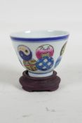 A Chinese polychrome porcelain tea bowl on a hardwood stand, Seal mark to base, 3" diameter