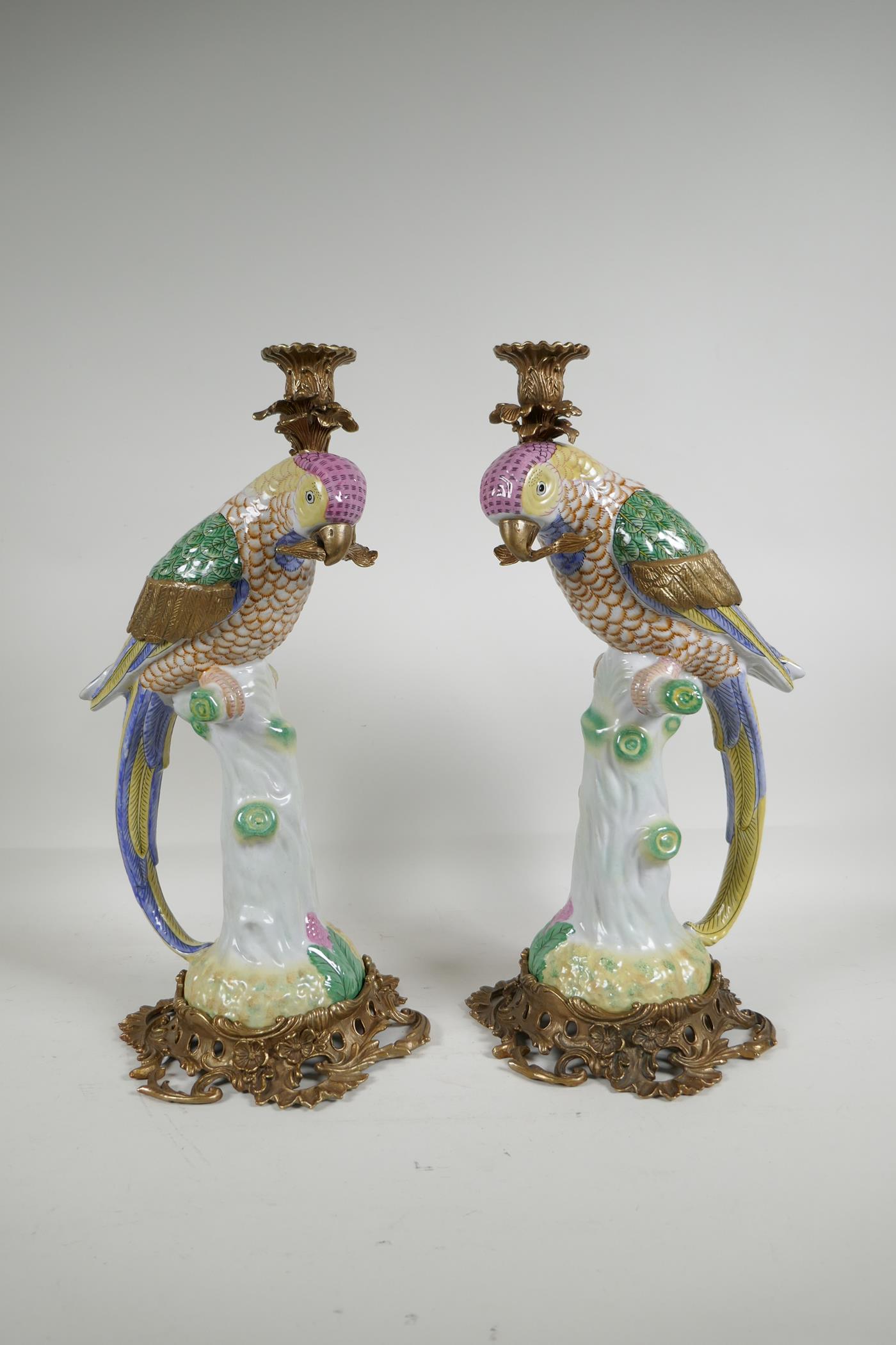 A pair of polychrome porcelain and gilt metal parakeet candlesticks, 16" high