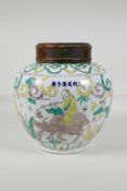 A Chinese Sancai glazed porcelain ginger jar with a turned wood cover, decorated with figures riding