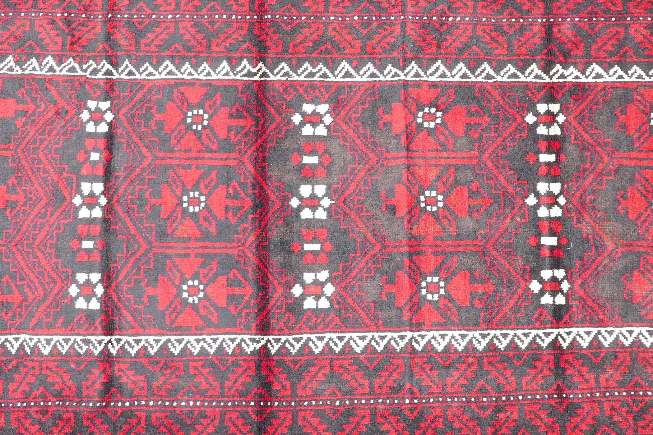 Hand woven full pile red and black ground Iranian Belouch rug, 50½" x 110"